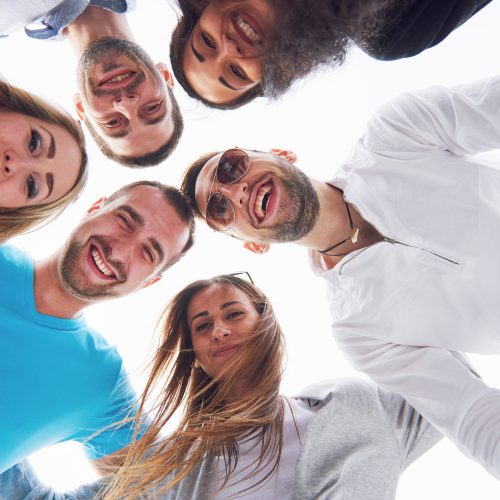 summer vacation, happy people - a group of teenagers looking down with a happy smile on his face